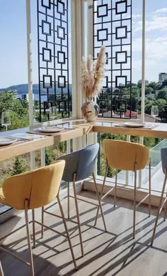 a table and chairs in a room with a window at Status-M Apartments 153 in Becici