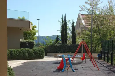 a playground with a bunch of swings in a yard at Status-M Apartments 153 in Becici