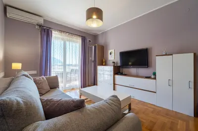 a living room with a couch and a tv at Lovely Studio with Panoramic City View in Budva