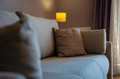 a blue couch with pillows in a living room at Lovely Studio with Panoramic City View in Budva