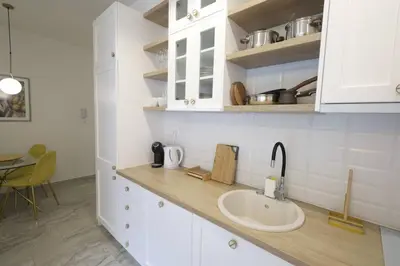 a kitchen counter with a sink and a table at Status-M Apartments Aura in Becici