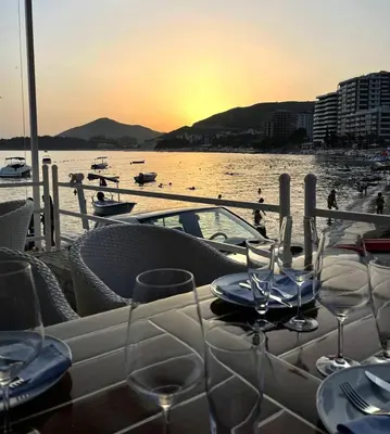a table with wine glasses on a boat in the water at Status-M Apartments Aura in Becici