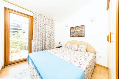 a bedroom with a bed and a large window at Harmony Budva Apartment in Budva
