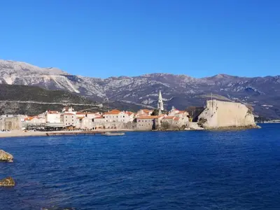 a view of a town on the water with mountains at Harmony Budva Apartment in Budva