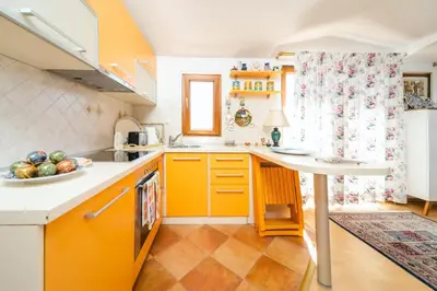 a kitchen with orange cabinets and a counter top at Harmony Budva Apartment in Budva