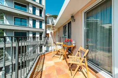 a balcony with two chairs and a table on it at Harmony Budva Apartment in Budva