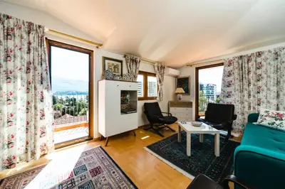 a living room with a couch and chairs and large windows at Harmony Budva Apartment in Budva