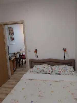 a bedroom with a bed and a dining room with a table at Apartmani Jaz 24 in Budva