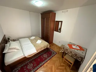 a small bedroom with a bed and a table at Budva App4 in Budva