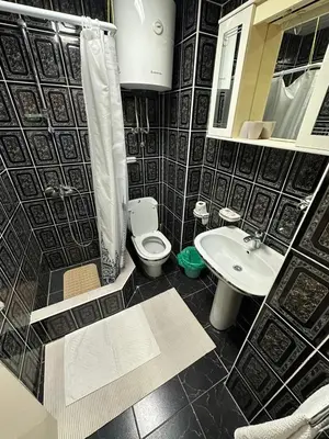 a black and white bathroom with a toilet and a sink at Budva App4 in Budva