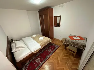 a small bedroom with a bed and a table at Budva App4 in Budva