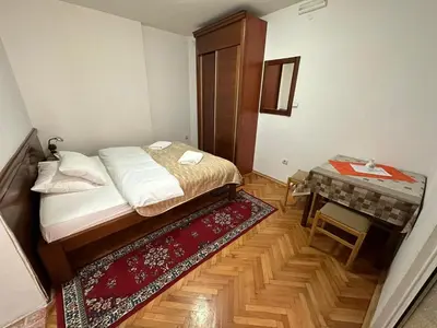 a small bedroom with a bed and a table at Budva App4 in Budva