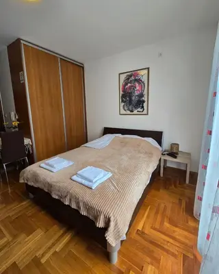 a bedroom with a bed with two towels on it at Laki Apartment in Podgorica