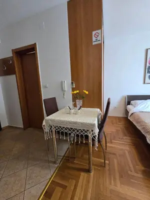 a room with a table and chairs and a bed at Laki Apartment in Podgorica