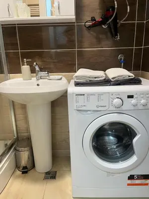 a bathroom with a washing machine and a sink at Budva City De Lux in Budva