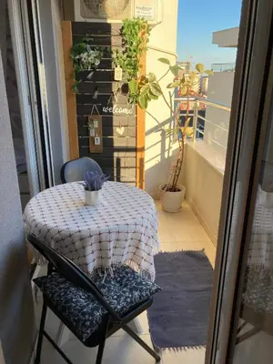 a table and chairs on a balcony with a table and a window at Budva City De Lux in Budva