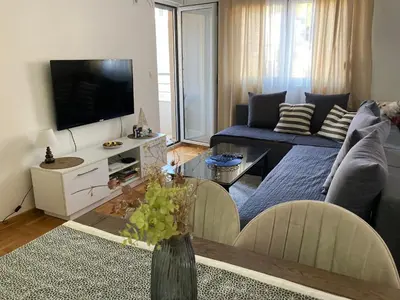 a living room with a couch and a tv at Budva City De Lux in Budva