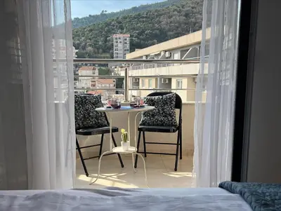 a bedroom with a table and chairs on a balcony at Budva City De Lux in Budva