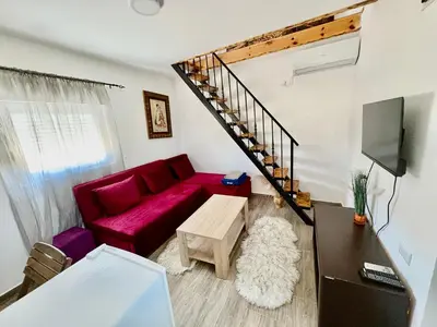 a living room with a red couch and a tv at Tiny house 2 - Imanje Terzic in Podgorica