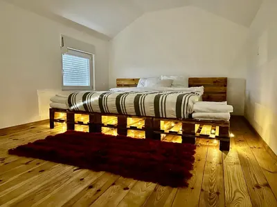 a bedroom with a bed on a wooden floor at Tiny house 2 - Imanje Terzic in Podgorica