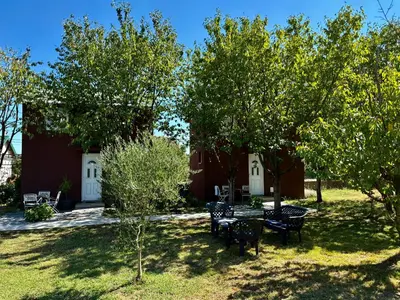 a yard with tables and chairs and trees at Tiny house 2 - Imanje Terzic in Podgorica