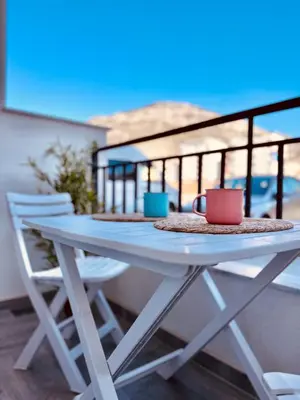a table on a balcony with two cups and chairs at Queen of the Beach in Bar