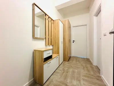 a hallway with a mirror and a dresser in a room at Queen of the Beach in Bar