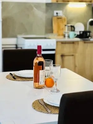 a bottle of wine sitting on a table with glasses at Queen of the Beach in Bar