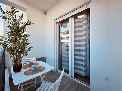 a table and chairs in a room with a window at Queen of the Beach in Bar