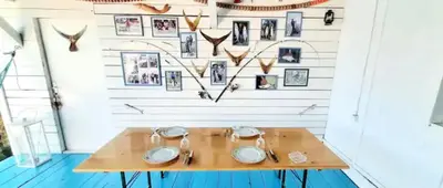 a table in a room with a wall with pictures at Kucica Truma in Ulcinj