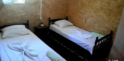 two beds in a room with white sheets and pillows at Kucica Truma in Ulcinj