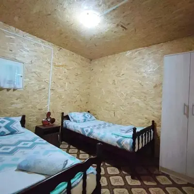 a bedroom with two beds and a stone wall at Kucica Truma in Ulcinj