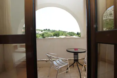 a table and chairs in a room with a window at Magnolia rooms and apartments in Sutomore
