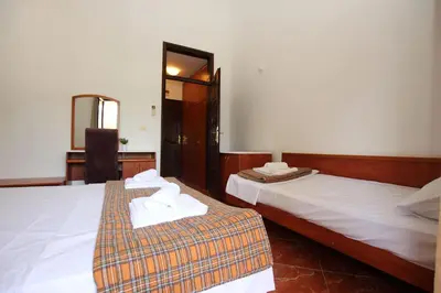 two beds in a hotel room with towels on them at Magnolia rooms and apartments in Sutomore