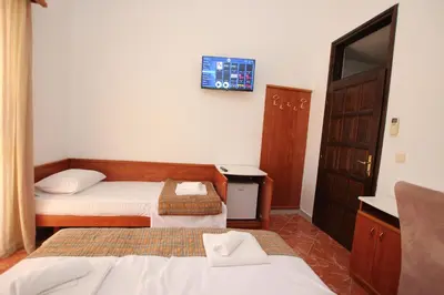 a small room with two beds and a door at Magnolia rooms and apartments in Sutomore