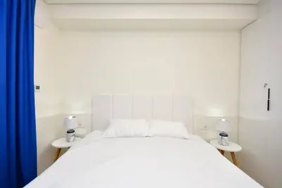a bedroom with a white bed with two tables at Brand New ! Seaside Apt with Poolview & Parking in Budva