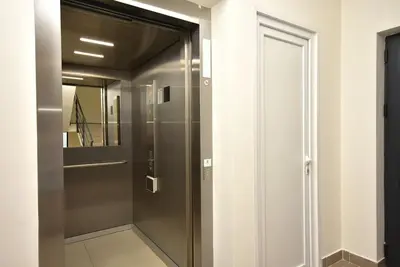 a glass door in a hallway with a mirror at Brand New ! Seaside Apt with Poolview & Parking in Budva