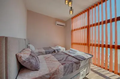 a bedroom with two beds next to a large window at PETROVIĆ in Bar
