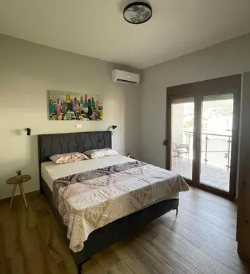a bedroom with a bed with a clock on the wall at PETROVIĆ in Bar