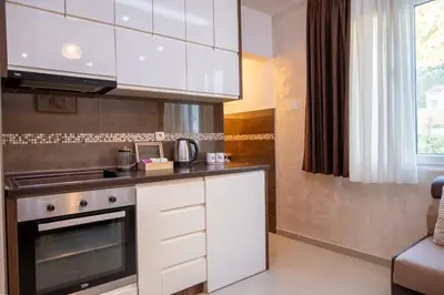 a kitchen with white cabinets and a stove at Apartman Milica-Mica in Kotor
