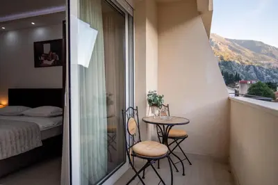 a small balcony with a table and chairs and a bed at Apartman Milica-Mica in Kotor