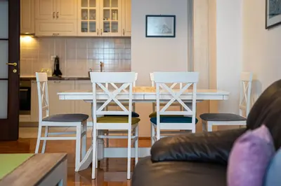 a kitchen with a table and four stools at Spacious two bedroom in Podgorica
