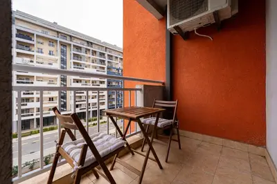 a balcony with two chairs and a table and a window at Spacious two bedroom in Podgorica