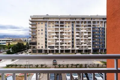 a apartment building with a car parked in front of it at Spacious two bedroom in Podgorica