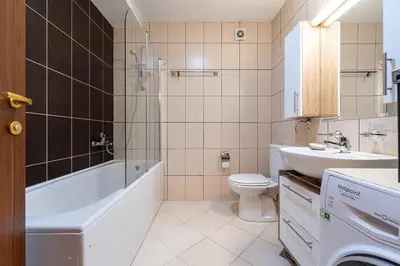 a bathroom with a tub and a toilet and a sink at Spacious two bedroom in Podgorica