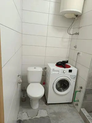 a bathroom with a toilet and a washing machine at Plaza Centar Podgorica in Podgorica