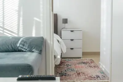 a bedroom with a couch and a dresser with a remote at One-Bedroom Apartment in the Center of Budva on a Quiet Street 5 Minutes to the Beach in Budva