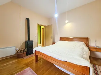 a bedroom with a bed and a wood stove at Lovćen Escape, Rustric House in Cetinje