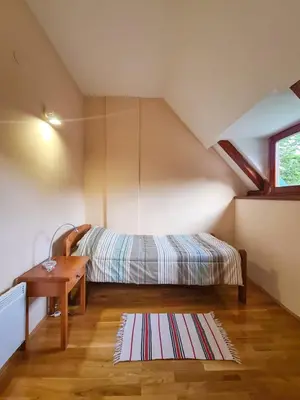 a bedroom with a bed and a desk and a table at Lovćen Escape, Rustric House in Cetinje