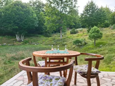a wooden table and two chairs on a patio at Lovćen Escape, Rustric House in Cetinje